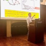 Jeremy Fineman points to a screen while standing at a podium.